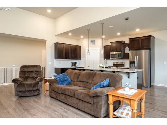 a living room with furniture kitchen and a flat screen tv