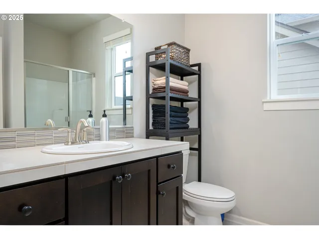 a bathroom with a granite countertop toilet sink and mirror