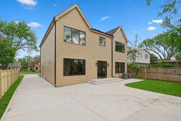 a front view of a house with a yard and trees