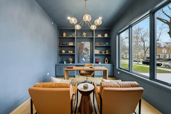 a view of a dining room with furniture a chandelier and wooden floor
