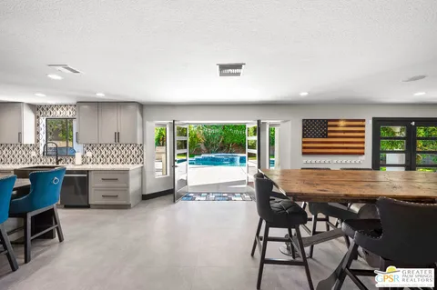 a kitchen with a table chairs sink and cabinets