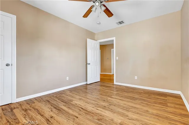 a view of room with wooden floor and ceiling fan