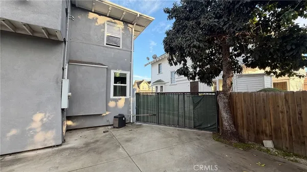 a view of a house with a tree and wooden fence