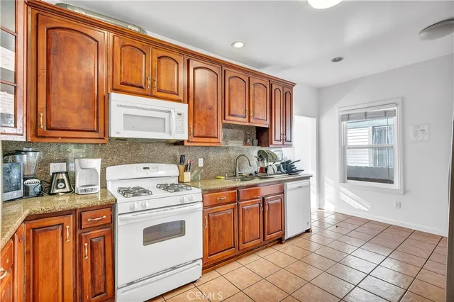 a kitchen with stainless steel appliances granite countertop a stove sink and cabinets