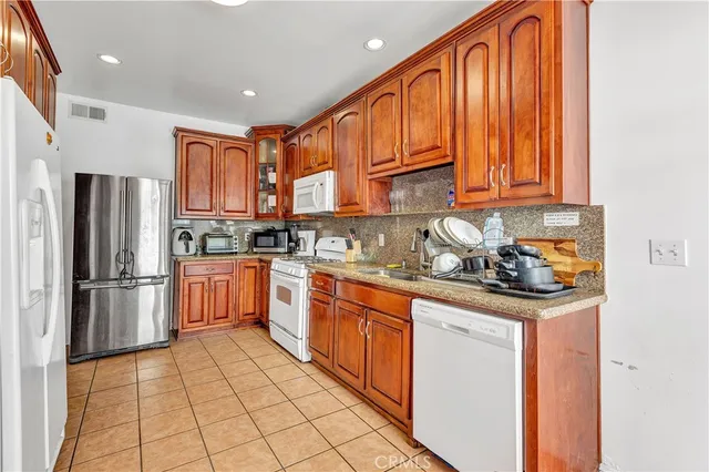 a kitchen with stainless steel appliances granite countertop a refrigerator sink and cabinets