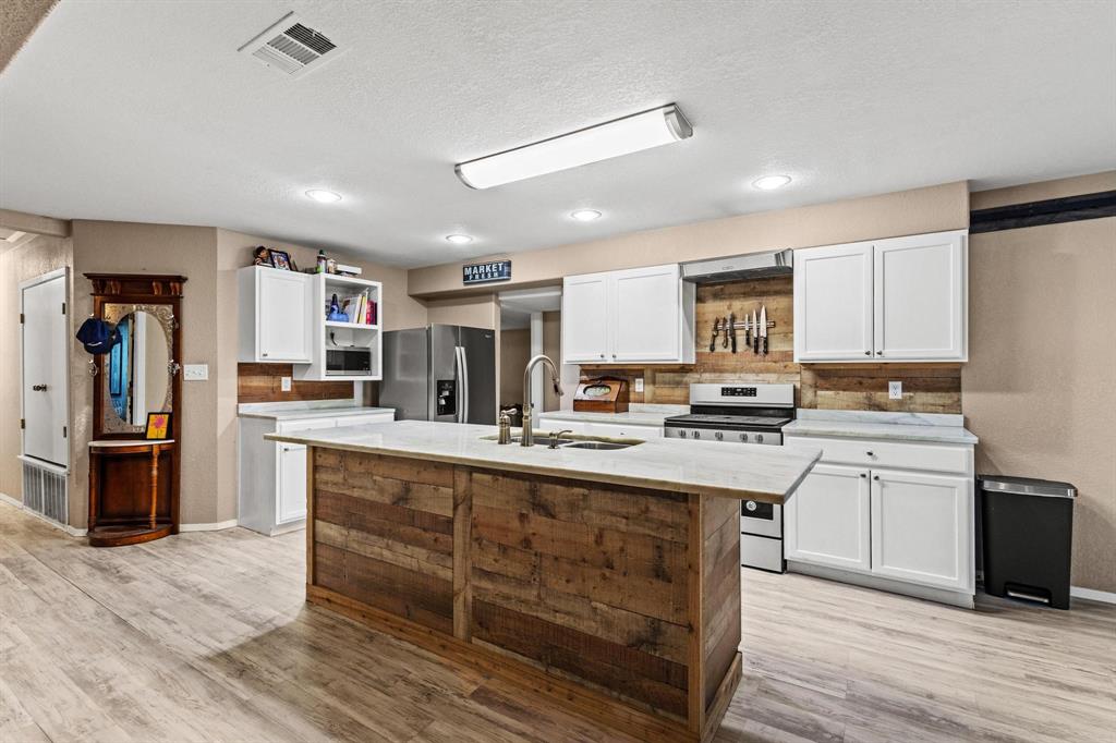469 Dugan Chapel Road Bells, TX 75414 - Photo 21 of 33 a kitchen with cabinets a sink and appliances