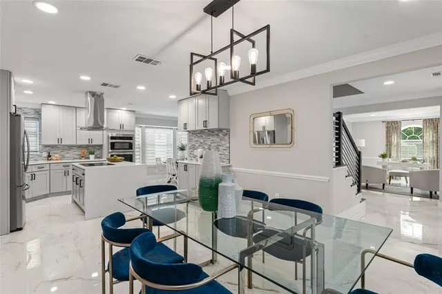 a kitchen with stainless steel appliances kitchen island granite countertop a refrigerator and a stove top oven