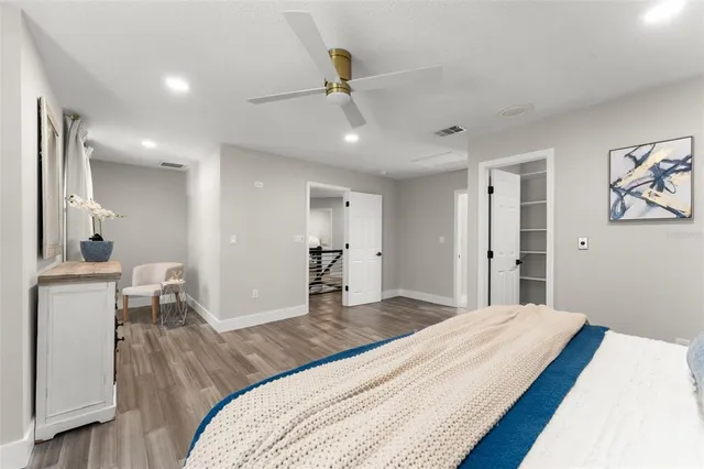 a bedroom with a bed and a wooden floor