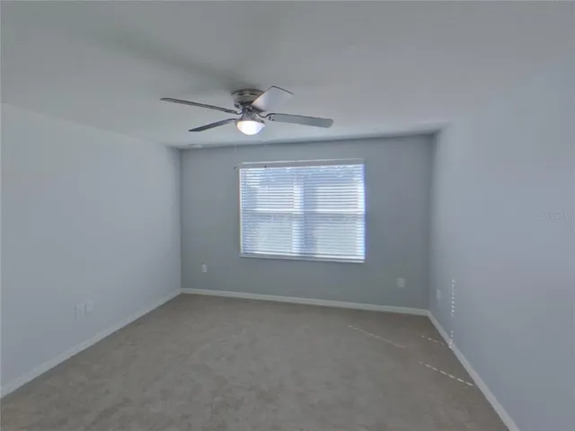 an empty room with a window and a ceiling fan