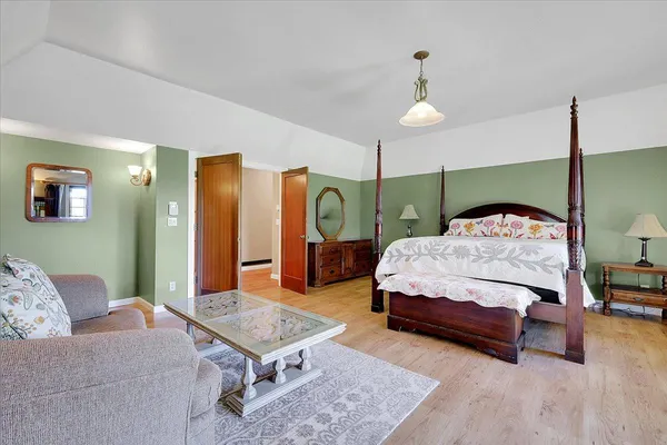 a dining room with furniture a chandelier and wooden floor