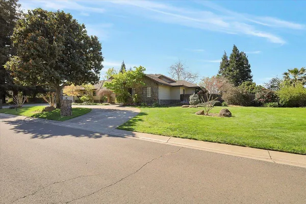 a view of a house with a big yard and palm trees