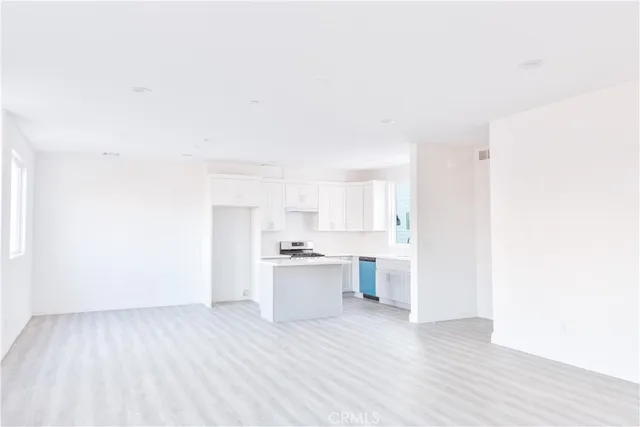 a view of a kitchen with a sink and dishwasher a refrigerator with wooden floor