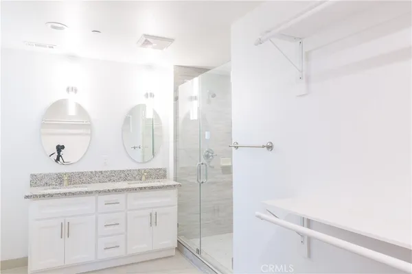 a bathroom with a granite countertop shower sink and mirror