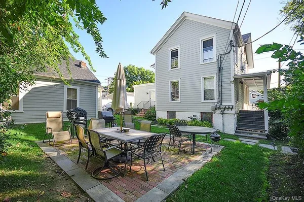 a view of a white house with a table and chairs in patio