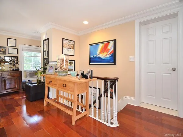 a living room with furniture a large window and wooden floor