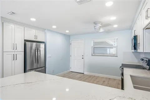 a kitchen with stainless steel appliances granite countertop a refrigerator sink and stove