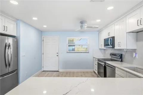 a kitchen with stainless steel appliances sink stove microwave and cabinets