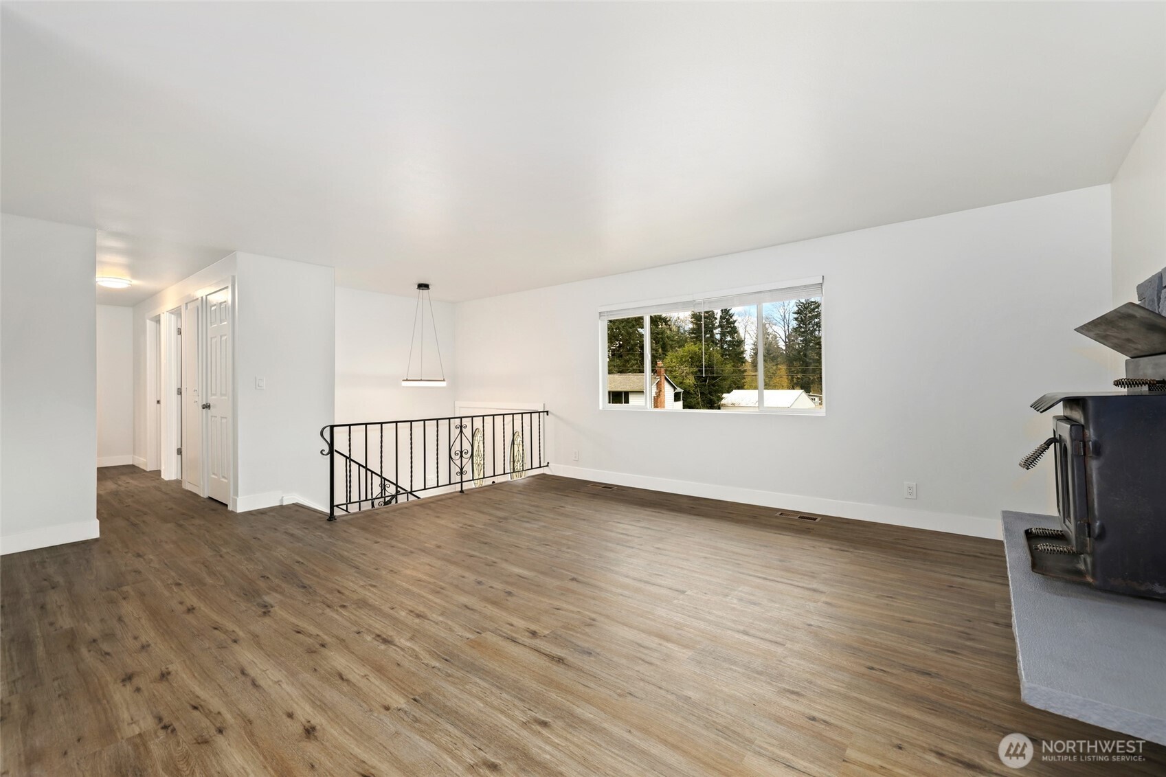 12637 Southeast 161st Street Renton, WA 98058 - Photo 4 of 37 a view of an empty room with a window and wooden floor