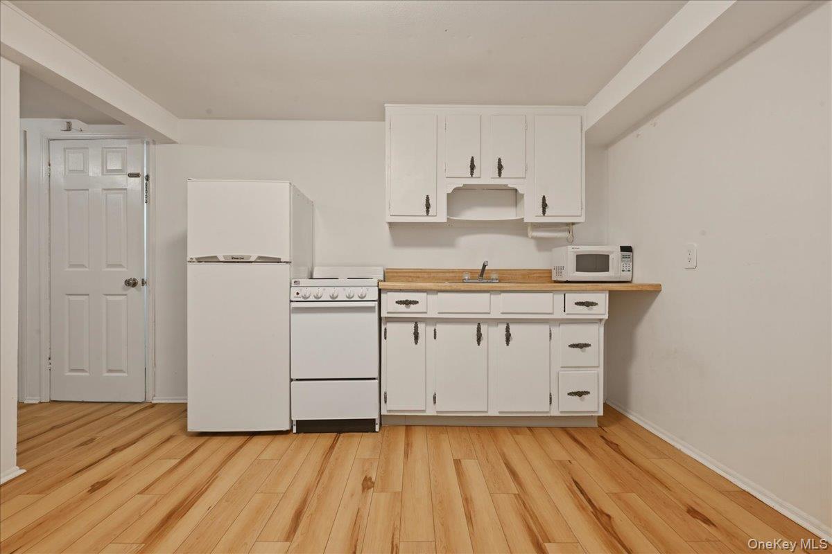 17 Avon Road Farmingdale, NY 11735 - Photo 32 of 46 a kitchen with a stove a sink and a refrigerator