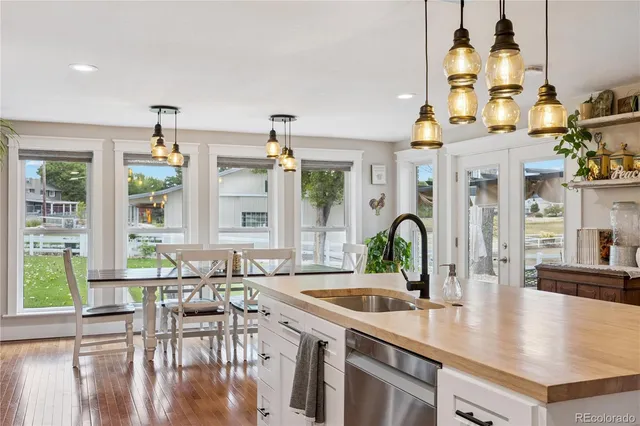 a kitchen with stainless steel appliances a table chairs and chandelier