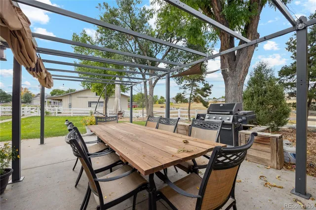 a view of a patio with a table chairs and a backyard