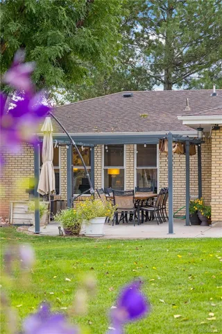 a view of a chair and table in backyard of the house