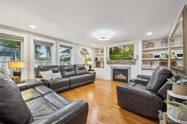 a living room with furniture a flat screen tv and a fireplace