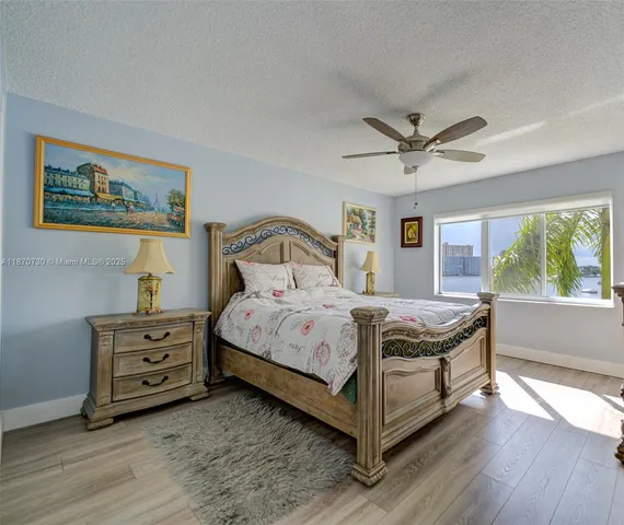 a bedroom with a bed a window and a painting on the wall
