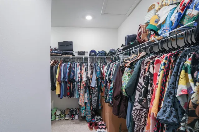 a view of walk in closet with clothes