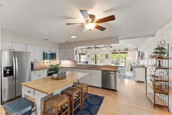 a kitchen with a table chairs refrigerator and microwave
