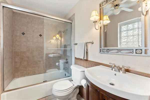 a bathroom with a bathtub shower sink mirror and toilet