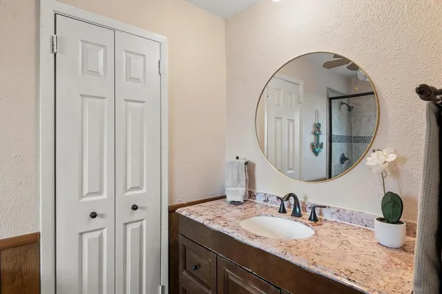 a bathroom with a granite countertop sink and a mirror