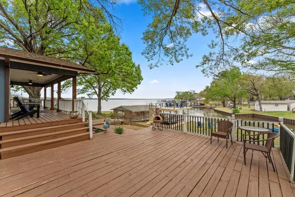 a view of a roof deck with table and chairs under an umbrella with wooden floor