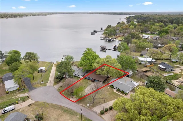 an aerial view of a house with a yard and lake view