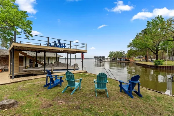 a view of a lake with chairs and table on the terrace