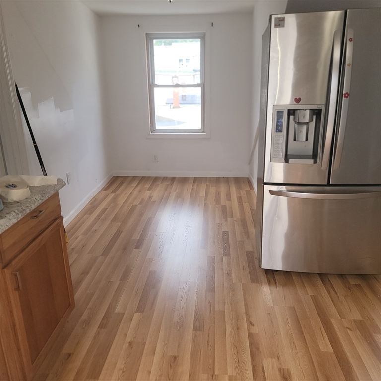 44-46 Butler Street Lawrence, MA 01841 - Photo 4 of 7 a kitchen with wooden floors and a refrigerator
