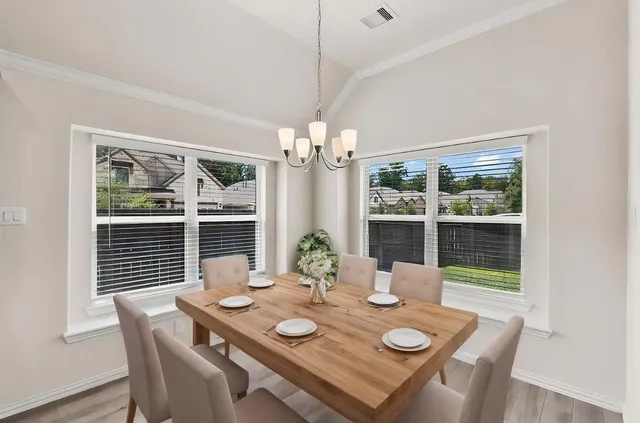 a view of a dining room with furniture wooden floor and chandelier
