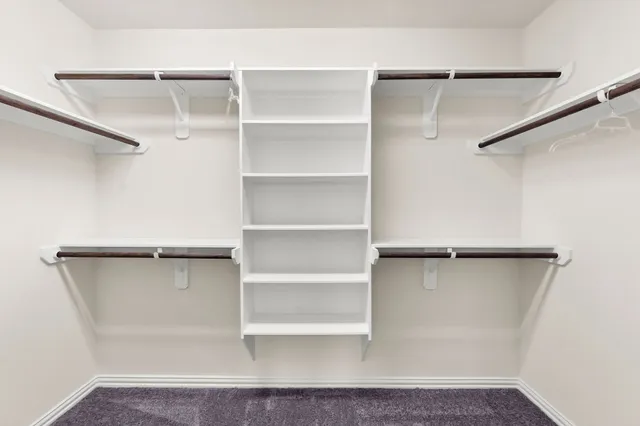 a view of walk in closet with empty racks