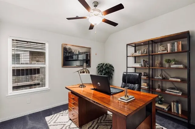 a view of a workspace with furniture and a window