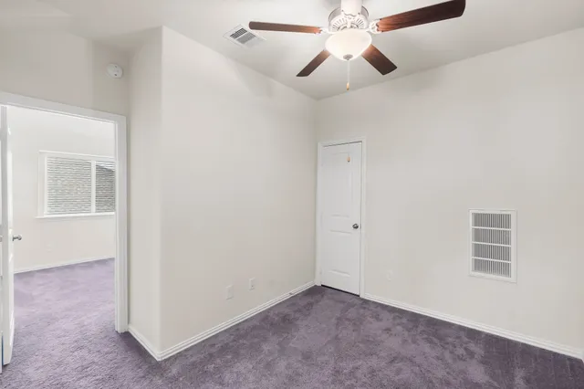 an empty room with chandelier fan