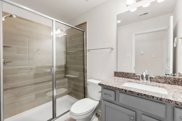 a bathroom with a granite countertop sink toilet and shower