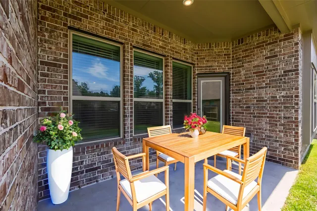 a patio with table and chairs potted plants