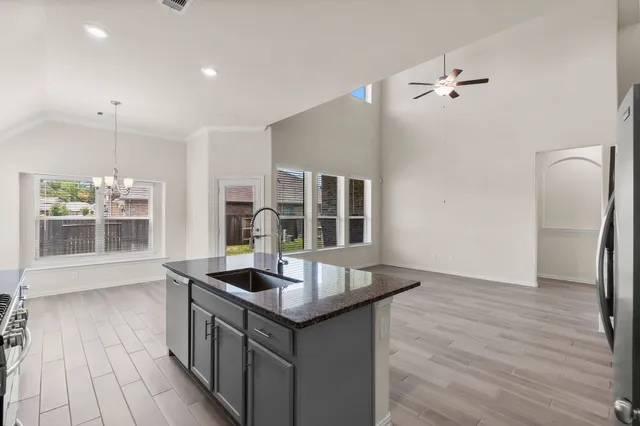 a kitchen with stainless steel appliances granite countertop a sink and wooden floor
