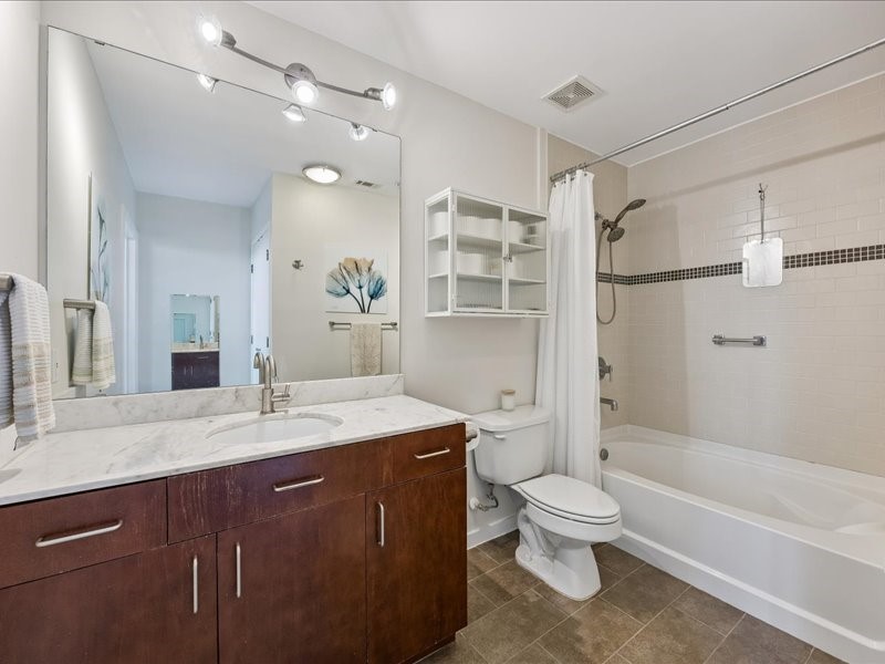 5925 Almeda Road, Unit 10714 Houston, TX 77004 - Photo 8 of 38 a bathroom with a granite countertop sink toilet a large mirror a bathtub and shower