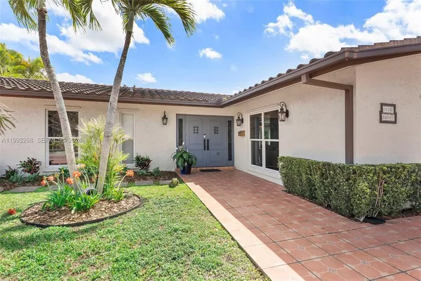 a front view of a house with a yard and potted plants