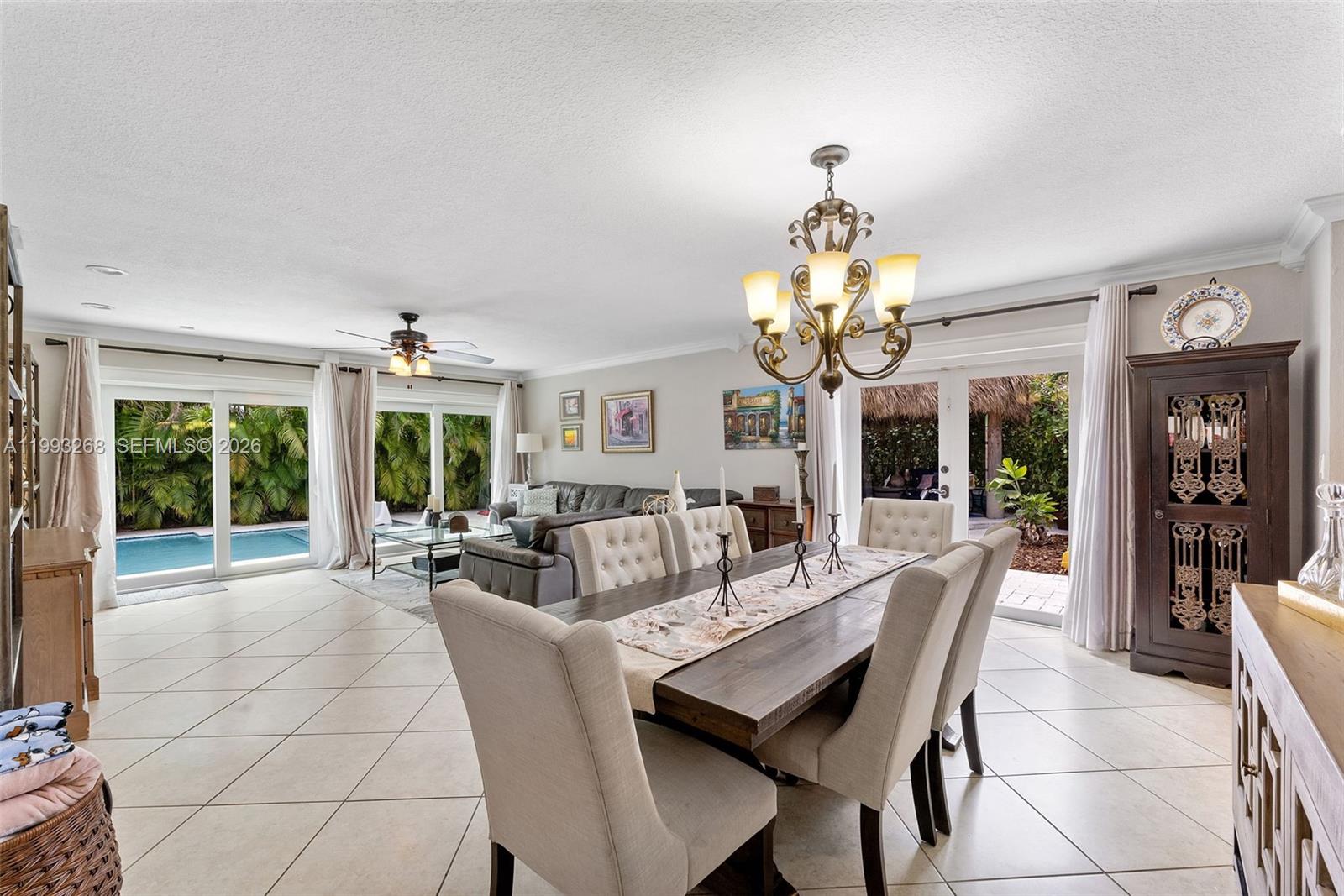 11798 Southwest 32nd Street Miami, FL 33165 - Photo 11 of 31 a dining room with wooden floor a chandelier a glass table and chairs