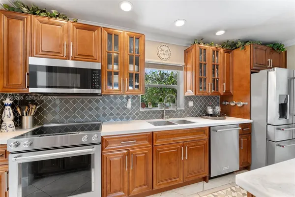 a kitchen with stainless steel appliances granite countertop a sink stove and refrigerator