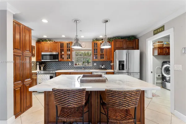 a kitchen with stainless steel appliances granite countertop a sink a stove and a refrigerator