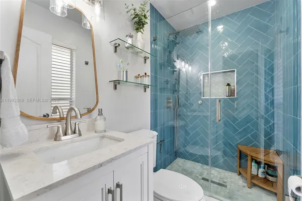 a bathroom with a sink toilet a mirror and shower