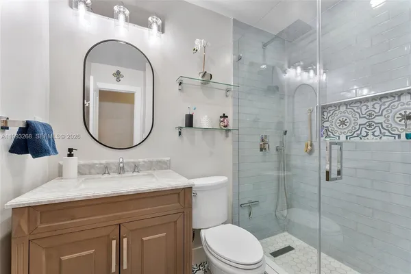 a bathroom with a sink a toilet and a mirror